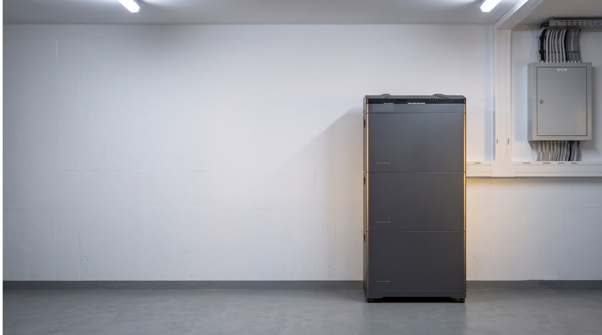 Stromspeicher als Stapelmodul an der Wand eines aufgeräumten Kellerraums, daneben der Zählerschrank